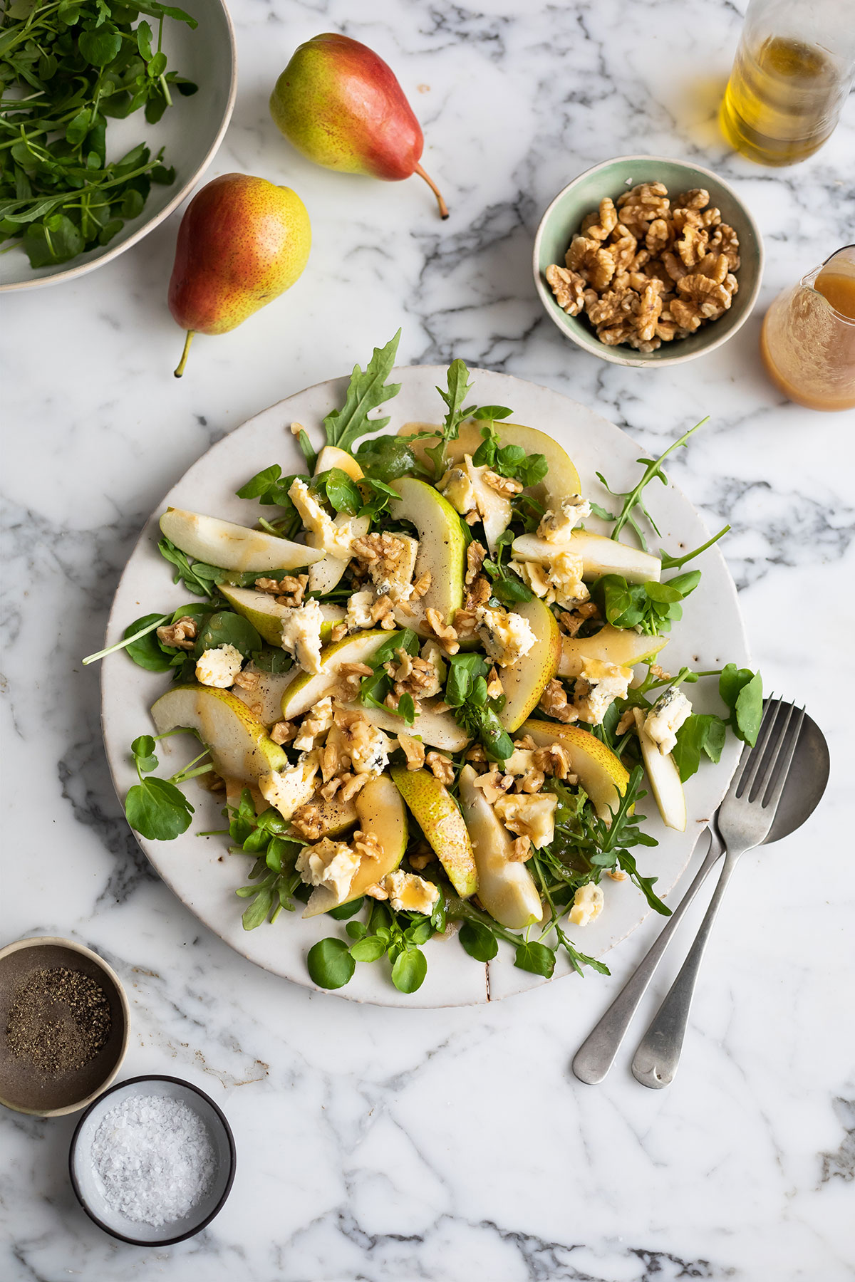 A classic pear, blue cheese & walnut salad with maple vinaigrette on a serving plate