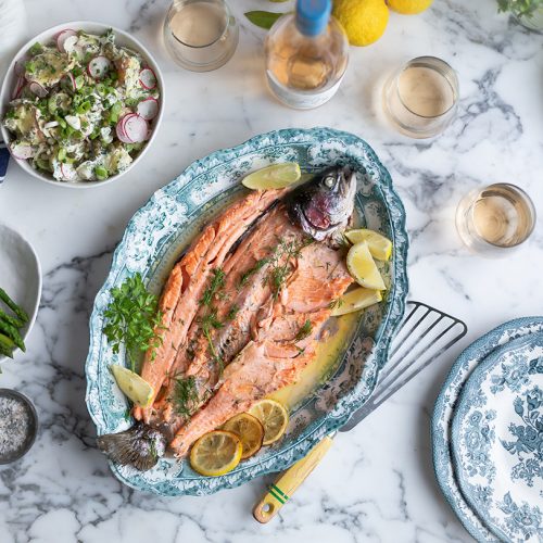 Whole baked trout with lemon & herbs on a serviing platter