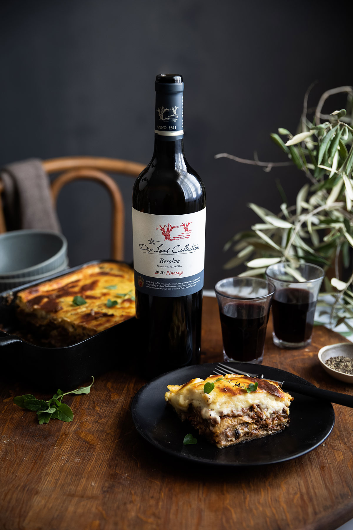 A bottle of wine with a classic Greek lamb moussaka