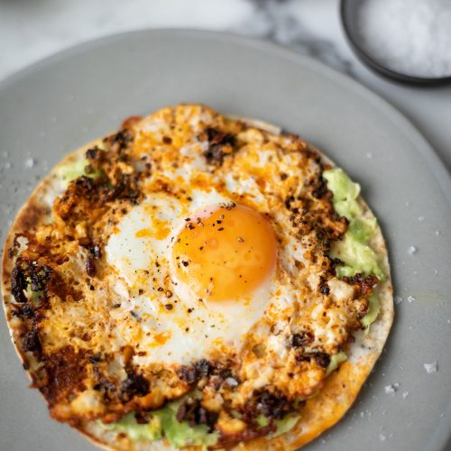 Eggs fried in chilli crisp oil on a flour tortilla with smashed avo (viral tik tok recipe)