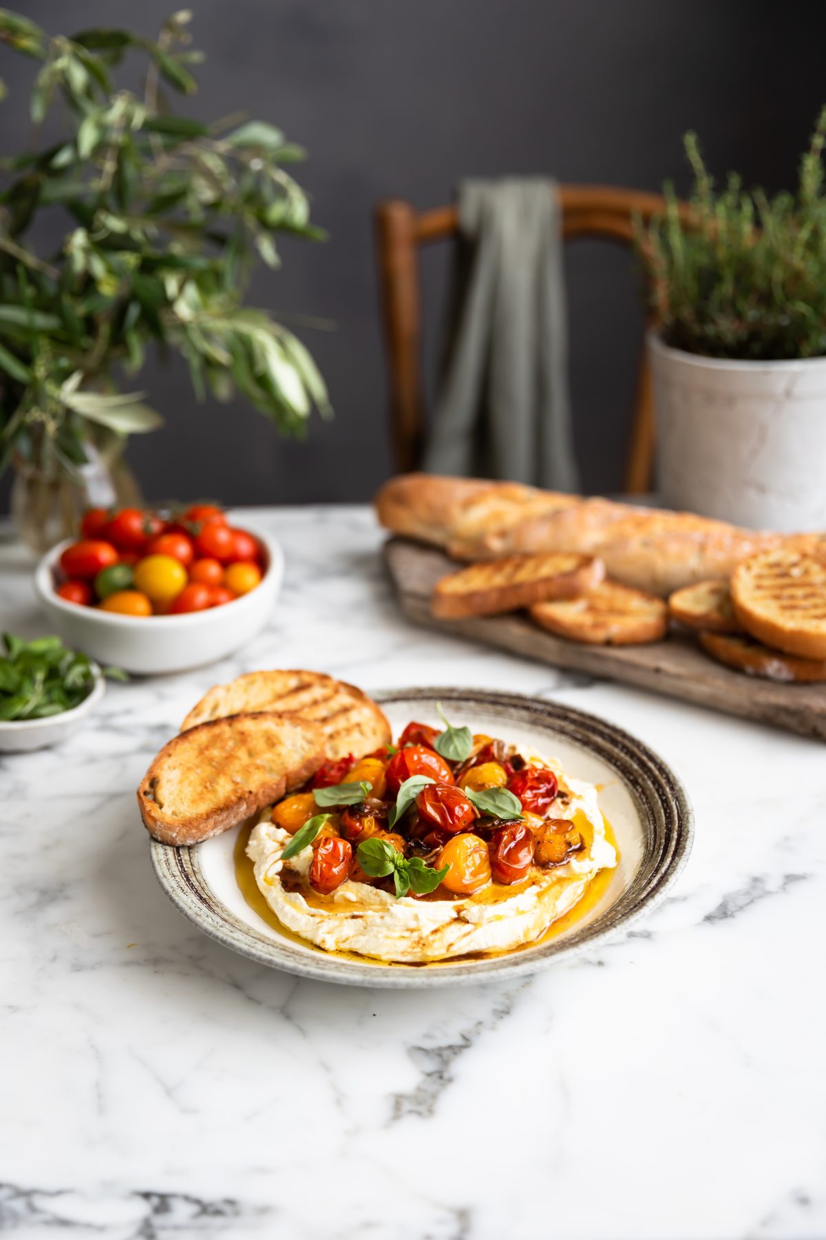 A plate with whipped feta with roasted tomatoes and garlic served with toasted ciabatta