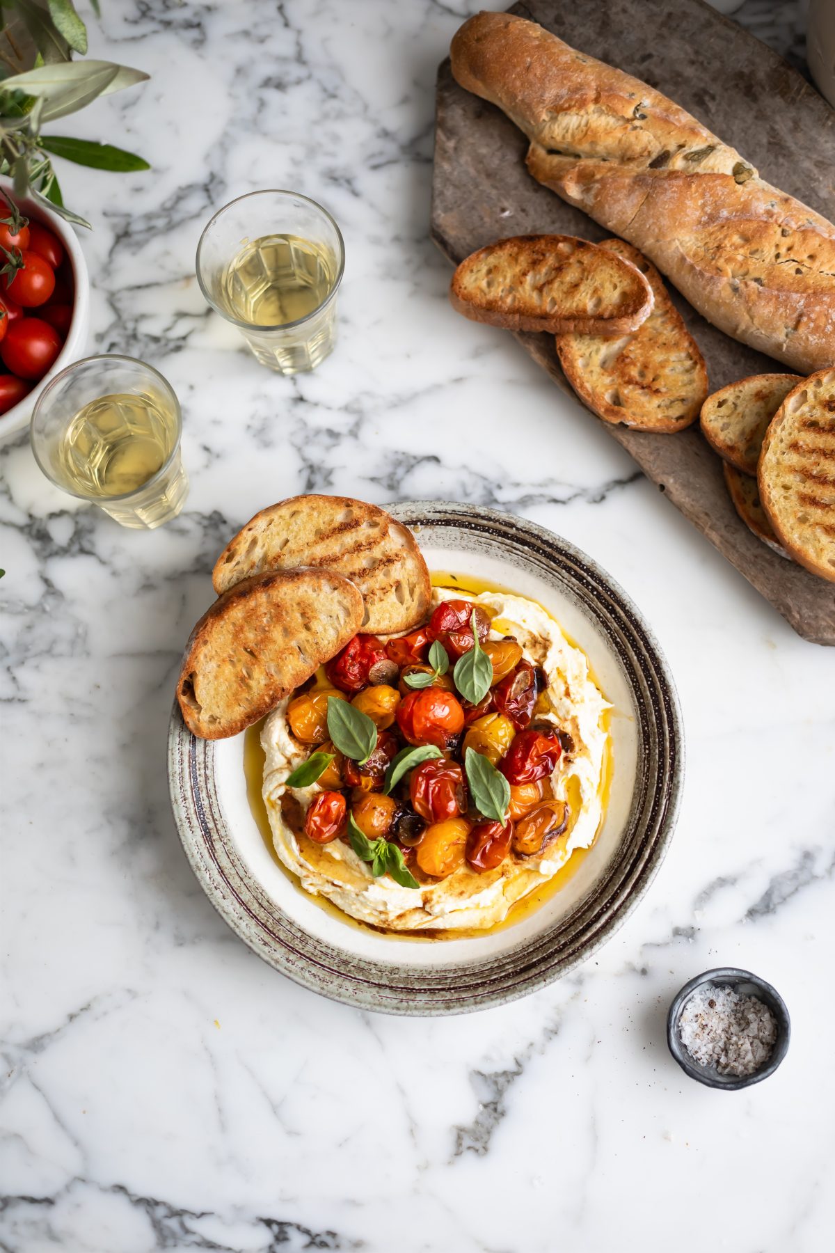 A plate of whipped feta with roasted tomatoes and garlic and toasted ciabatta