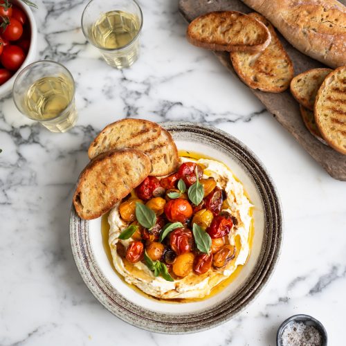 A plate of whipped feta with roasted tomatoes and garlic and toasted ciabatta