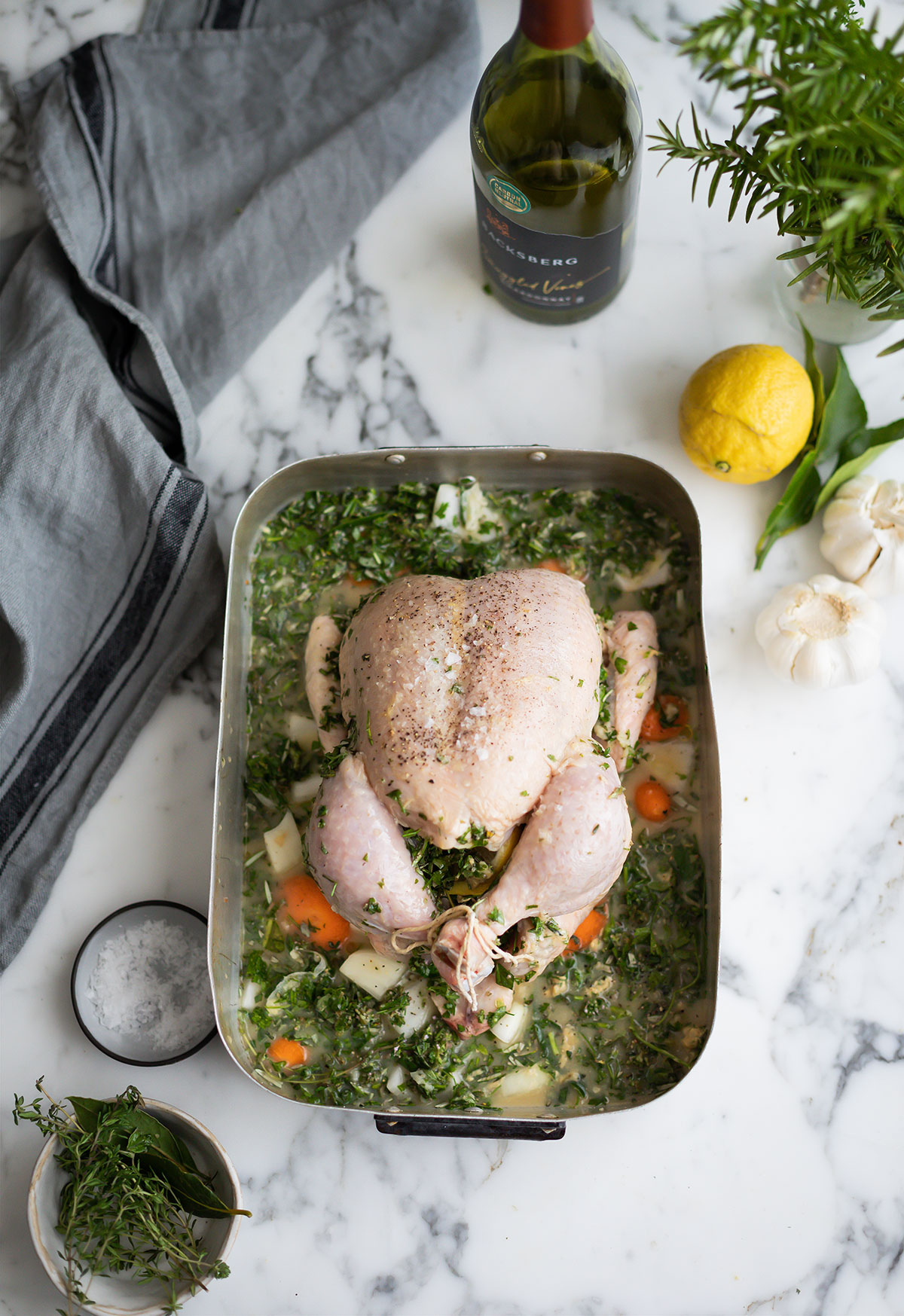 A raw chicken about to be turned into the best roast chicken with wine, herbs and garlic recipe