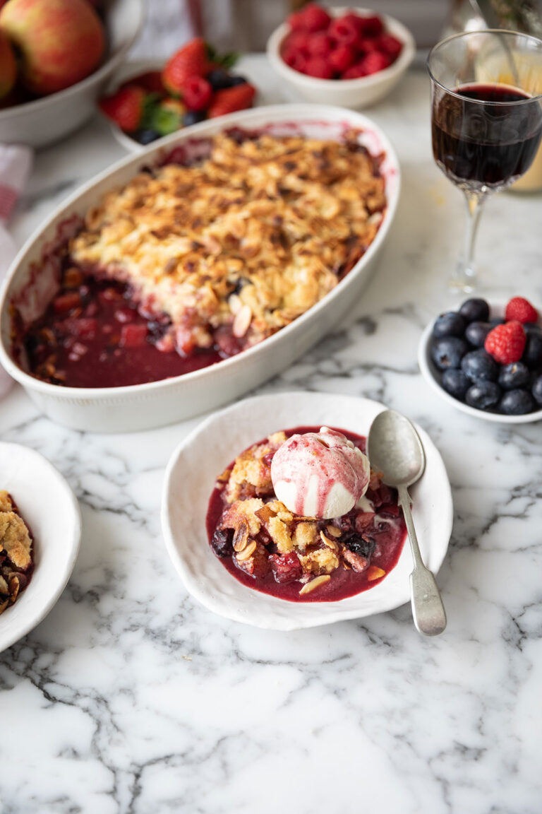 Apple and berry crumble with vanilla ice cream dished up